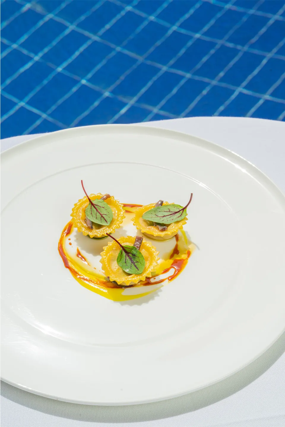 Gourmet stuffed pasta dish with refined plating by the pool at Hotel Metropole Taormina