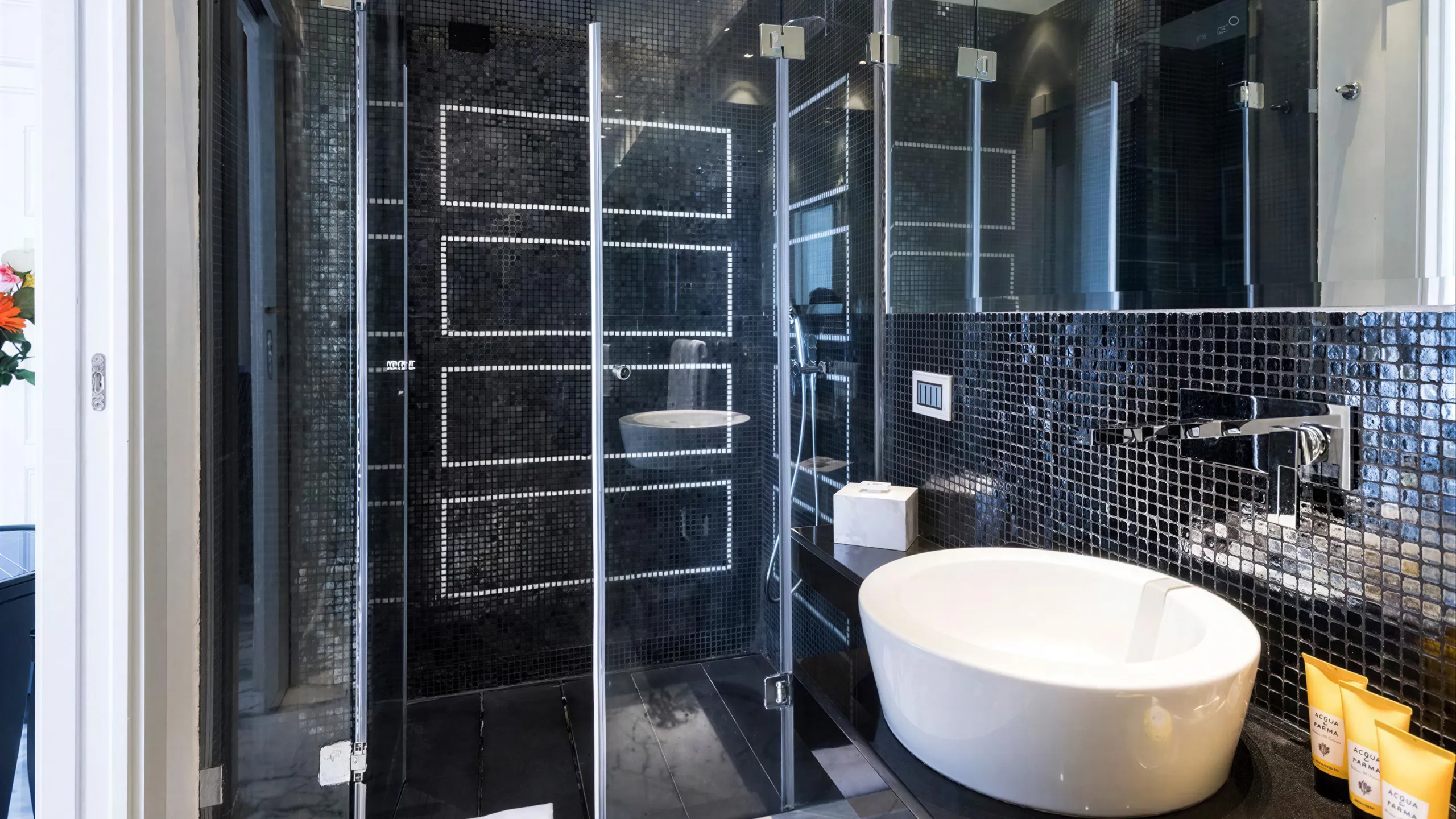 Sea view Deluxe Room bathroom: black mosaic tiles, glass shower, bowl sink and Acqua di Parma amenities